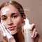 Female applying glowoasis mandarin orange peel cloudcleanse probiotics face wash to her forehead and cheek.