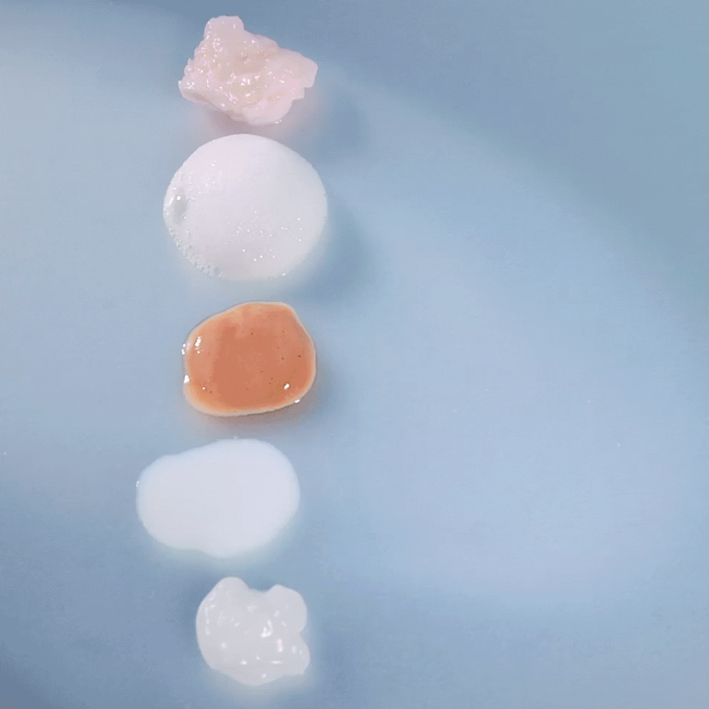 glowoasis vegan probiotic ultimate oasis full skincare set’s textures displayed on a blue background.