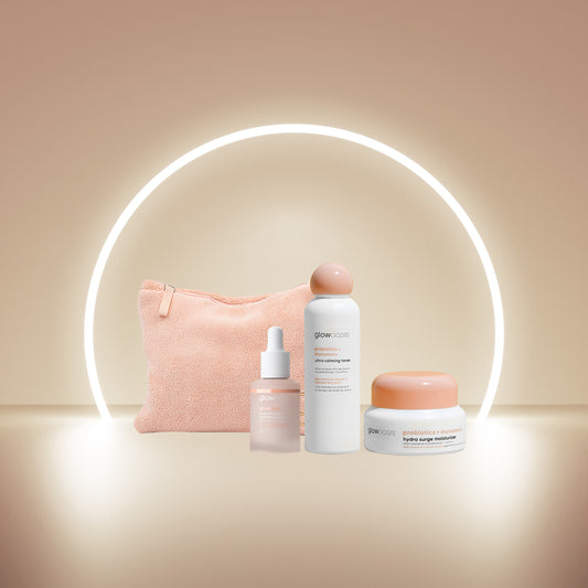 glowoasis vegan probiotic winter radiance kit laid out in front of a glowy beige background, featuring glowshot supercharged hydrating serum, murumuru butter hydra surge moisturizer, and ultra calming toner.