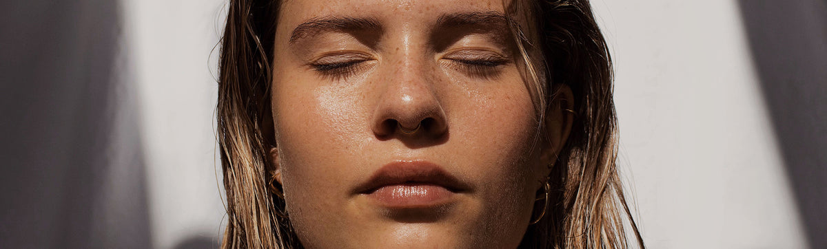 a woman showcasing skincare products that support microbiome for healthy aging 