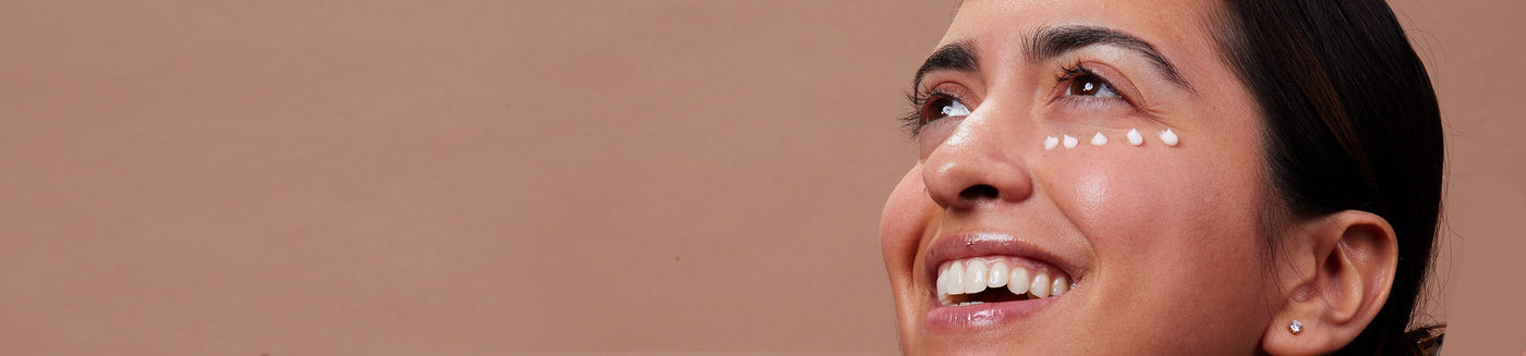 smiling female with skincare applied under the eye