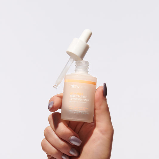 Hand holding glowoasis vegan probiotics glowshot supercharged hydrating serum.