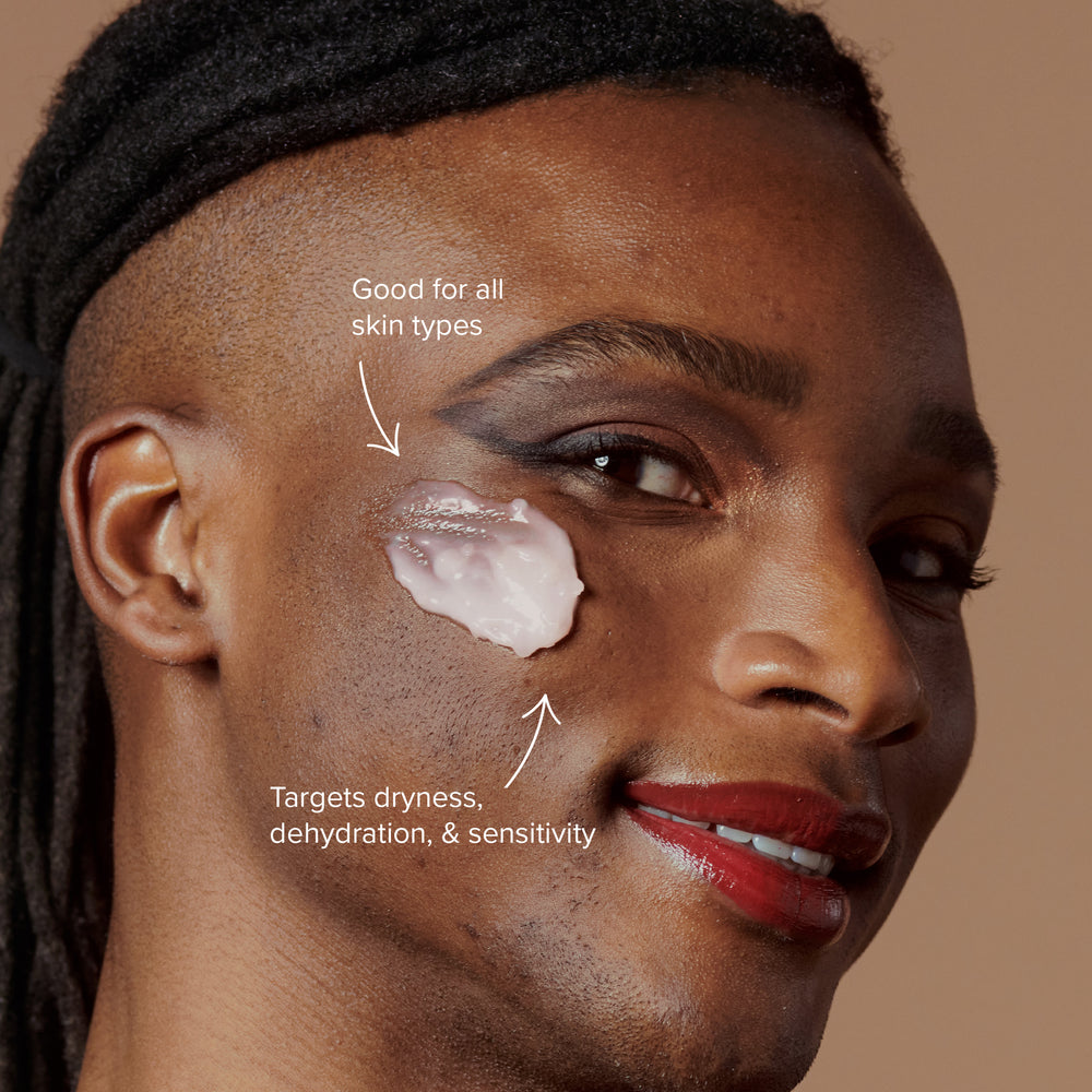 Smiling male model with glowoasis vegan probiotics moringa oil makeupmelt cleansing balm applied to cheek showing the makeup remover is suitable for all skin types and targets dehydration, dryness, and sensitivity.